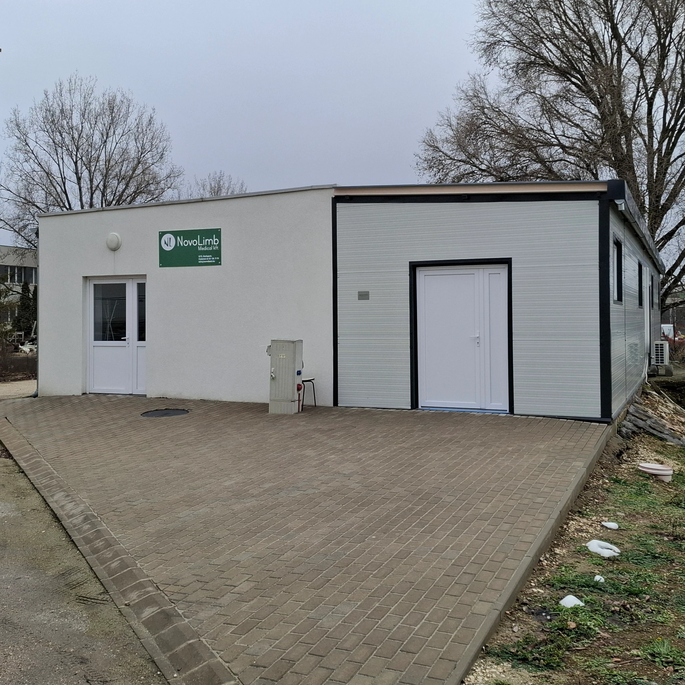 A NovoLimb műhely fehér épülete kényelmes parkolási lehetőséggel és akadálymentesített bejárattal.